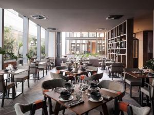 ein Restaurant mit Tischen und Stühlen und großen Fenstern in der Unterkunft Novotel Perth Murray Street in Perth