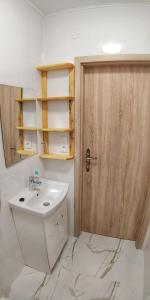 La salle de bains est pourvue d'un lavabo et d'une porte en bois. dans l'établissement Moravský Grunt Konírna, à Olomouc