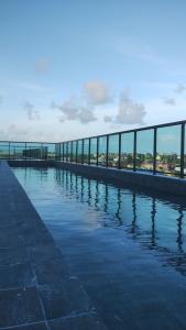 a large pool of water with a building in the background at STUDIO PORTO PRIME PREMIUM in Porto De Galinhas