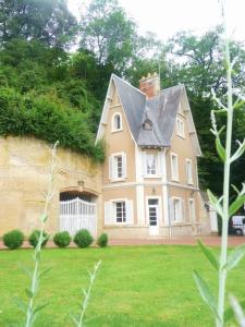une grande maison avec un toit gris sur une cour dans l'établissement Maison Dans Le Parc Du Château, à Larçay
