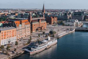 Story Hotel Studio Malmo, part of JdV by Hyatt في مالمو: اطلالة جوية على مدينة بها نهر