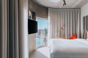 a hotel room with a bed and a window at Story Hotel Studio Malmo, part of JdV by Hyatt in Malmö