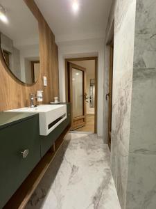 a bathroom with a sink and a mirror at APARTAMENT OVOC 1.0 in Chodzież