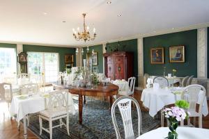 comedor con mesa y sillas blancas en Hotel Forsthaus Damerow en Ostseebad Koserow