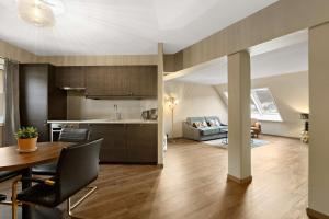 a kitchen and living room with a table and a couch at Ole Bull, Best Western Signature Collection in Bergen