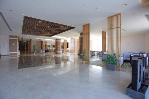 een lege lobby met tafels en stoelen in een gebouw bij Dar Hashim Hotel Suites - Alnuzha in Riyad