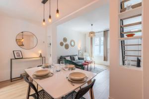 een eetkamer en een woonkamer met een tafel en stoelen bij 2 BR house w/ terrace, near train stations & metro in Lille