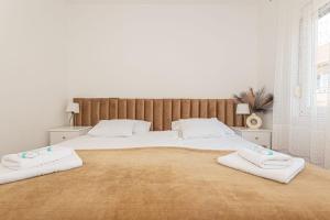 a bedroom with a large bed with towels on it at Apartment Mozart in Šibenik