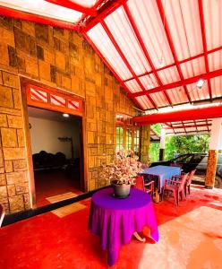 eine Terrasse mit einem Tisch und einer Vase darauf in der Unterkunft Knuckles bungalow in Rattota