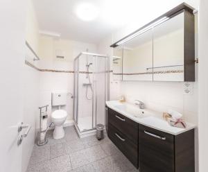 a bathroom with a toilet and a sink and a shower at Marbijes Appartementhaus in Cuxhaven +226 photos