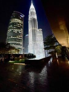a tall building with lights in a city at night at 1 min to KLCC Twin Tower in Kuala Lumpur