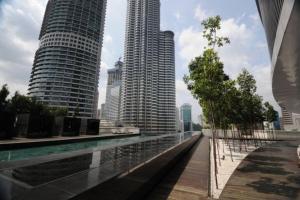 a view of two tall buildings next to a swimming pool at 1 min to KLCC Twin Tower in Kuala Lumpur