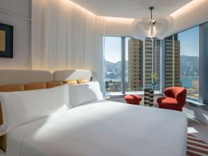 um quarto com uma grande cama branca e uma grande janela em Mondrian Hong Kong em Hong Kong