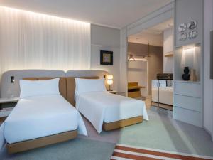 a hotel room with two beds and a bedroom at Mondrian Hong Kong in Hong Kong