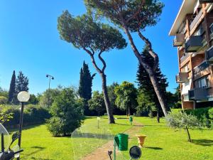 uma vista para um parque com árvores e um edifício em Modern apartment 10 min to Vaticans Museums with parking & garden em Roma
