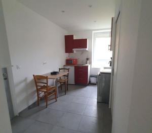 a kitchen with a table and chairs in a room at Le Coquelicot : appartement T1 in Héricourt +2 photos