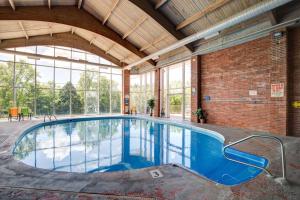 an indoor pool in a building with a brick wall at Ramada by Wyndham Branson Theatre District in Branson