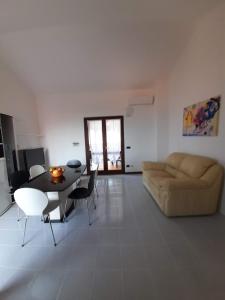 salon z kanapą, stołem i krzesłami w obiekcie Casa Antonietta Villetta incantevole Vista Mare w mieście Funtana Meiga