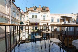 a balcony with two tables and chairs on a building at Kyiv Prince Apartment in Kyiv