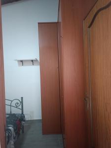 una porta che conduce a una camera con un letto e una porta in legno di Casa Cristina a Quartu SantʼElena