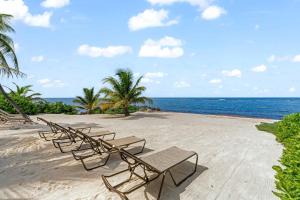 a row of chairs on a beach with the ocean at Gypsy Villa home in Driftwood Village