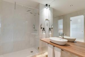 a bathroom with two sinks and a glass shower at Pestana Sintra Golf Resort & SPA Hotel in Sintra