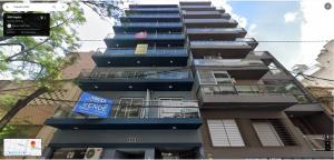 un edificio alto con balcones a un lado. en Departamento, Excelente calidad y Ubicación, a estrenar en Rosario