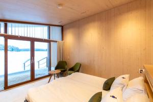 a bedroom with two beds and a large window at Bella Lake Resort in Kuopio