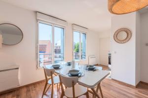 a white dining room with a white table and chairs at Quiet 1 bedroom apartment parking Old Lille in Lille