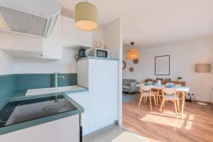 a kitchen with a refrigerator and a table with chairs at Quiet 1 bedroom apartment parking Old Lille in Lille +13 photos