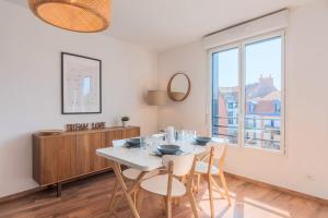 a dining room with a table and chairs and a window at Quiet 1 bedroom apartment parking Old Lille in Lille