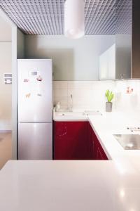 een keuken met een witte koelkast en rode kasten bij Park View Apartment in Tirana