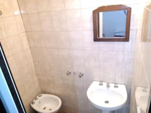 a bathroom with a sink and a toilet and a mirror at Hotel Minerva in Buenos Aires