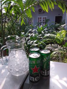 duas latas de cerveja sentadas numa mesa ao lado de um jarro de água em MOTEL MINH TÂM 28 