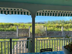 a patio with a table and chairs and an umbrella at CosyLife Sainte-Rose - Villa calme avec vue Sofaïa à 3km de la plage in Sainte-Rose