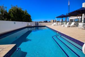 a swimming pool with chairs and umbrellas on a building at Dockside Brisbane in Brisbane