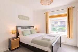 Un dormitorio con una cama grande y una ventana en The Nest by Afan Valley Escapes, en Port Talbot