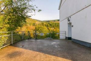 an empty porch of a white building with a balcony at The Nest by Afan Valley Escapes in Port Talbot