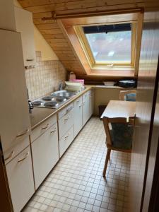 a small kitchen with a sink and a window at Titiseehnsucht - Gemütliche Wohnung mit Parkplatz in Titisee-Neustadt