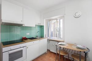 a kitchen with white cabinets and a small table at Maison Étoile - Appartamento Luna in Aosta