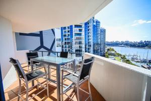 a balcony with a table and chairs and a view at Dockside Brisbane in Brisbane