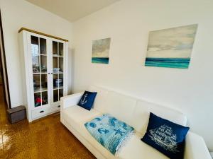 - un salon avec un canapé blanc et des oreillers bleus dans l'établissement GRADISSIMO, à Grado-Pineta