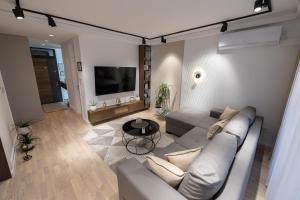 ein Wohnzimmer mit einem Sofa und einem Flachbild-TV in der Unterkunft Vividlux Apartments in Aranđelovac