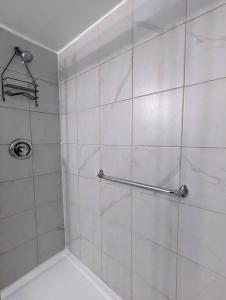y baño con ducha y paredes de azulejos blancos. en Studio 5 mins to Water in Elliot Lake, Ontario, en Elliot Lake