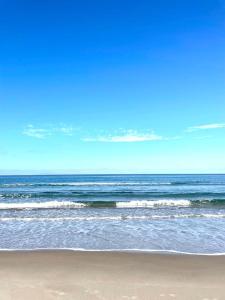 einen Strand mit Wellen im Ozean an einem klaren Tag in der Unterkunft I Gerani Country House in Sorso