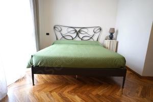 a bedroom with a bed with a green comforter at Case Ospitali - Corte Nuova appartamento in corte storica con due camere e due bagni in Caponago