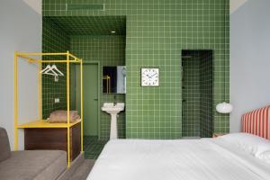 a green tiled bathroom with a bed and a sink at Armesto Rooms in Madrid