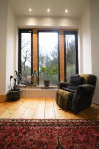 a living room with a couch and a large window at Crow Nest House in Hebden Bridge