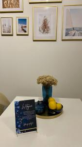 una mesa con un libro y un jarrón y fruta en Ann's Apartment, en Białystok