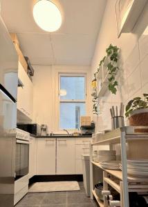 a kitchen with white cabinets and a window at Cozy, Bright and Best Value Gem at Potts Point - 2 km to Sydney CBD in Sydney